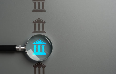 Bank research. Magnifying glass and a bank. Interest rates, investment opportunities, and regulatory...