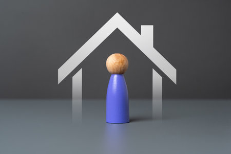 A man under the roof of a house. Providing housing. Affordability, accessibility, and sustainability. Addressing the basic human need for shelterの写真素材