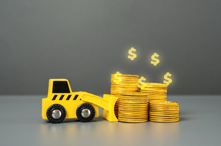 Bulldozer and a stack of coins. Deposits and savings. Invest in the project. Lose money. Confiscation and freezing of assets. Blocking of accounts. Construction and housing.の写真素材