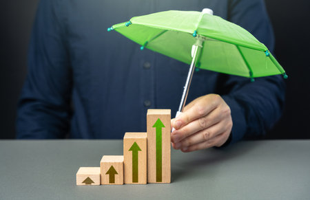Businessman holding protection umbrella over growth graph. Career advancement. Achieve success and...