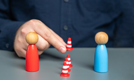 A man sets up a barrier of cones between people in conflict. Concept of the demarcation line....
