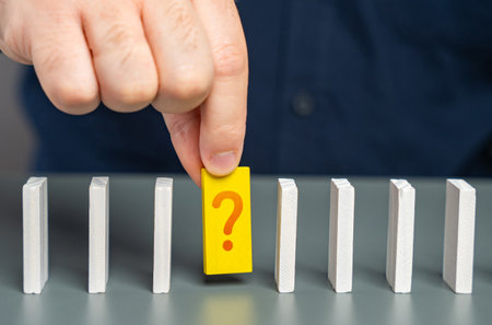 A man studies an unknown element of a chain of processes in the form of dominoes. Finding an answer...