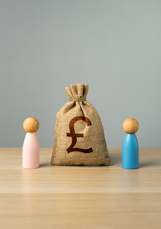 British pound sterling bag between couples in a relationship. Joint budget. Financial relations. Division of property during divorce.の写真素材