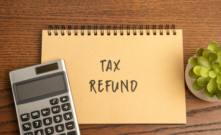 Tax refund concept - return of excess taxes paid to the government by a taxpayer. Business and finance. Notebook with description and calculatorの写真素材