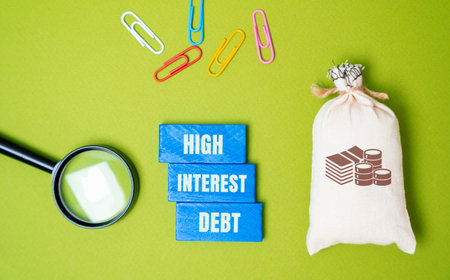 High-interest debt concept - borrowed money with a high interest rate. Wooden blocks with an inscription, a money bag and a magnifying glass. Business and financeの写真素材