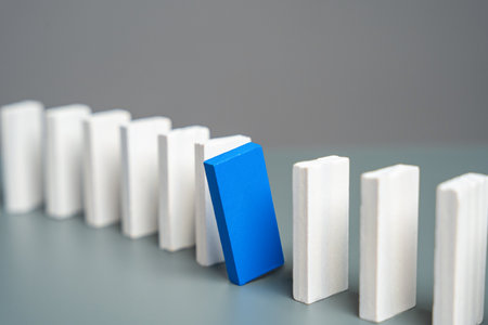 A blue domino peeks out from a row of white ones. Stand out. Initiative and talent. Unique and specialの写真素材