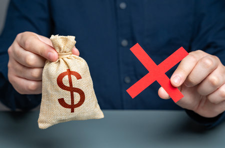 Man holding red cross and dollar money bag. Refusal to grant a loan. Failure to return the collateral. Refusal of sale and cooperation. Risk of confiscation of funds.の写真素材