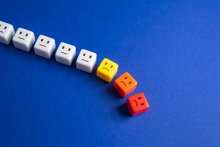 Blocks with faces crumbles, the unfortunate ones leave the line. Falling popularity, decreasing viewers or customers. Participants and employees leaving. Bad mood, difficulties and toxic environment.の写真素材