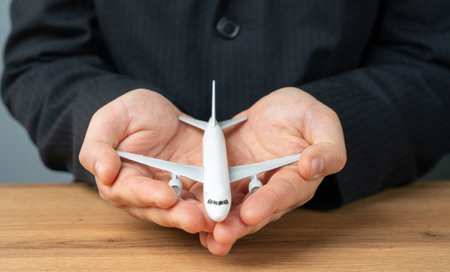 An airline plane in the palms of a businessman or official. Aircraft leasing and insurance by airlines. The importance of air travel. Investments in the air transport industry.の写真素材