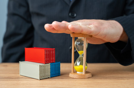 Shipping containers and hourglass supplied by businessman. Delivery times. Acceleration of cargo transportation. Importance of timely delivery, efficient logistics, and faster transportation.の写真素材