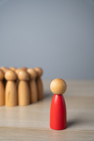 The red man stands away from the group, rejected and exiled. Social exclusion, rejection, workplace discrimination, loneliness, isolation, and being an outcast. Social pressure, and nonconformity.の写真素材