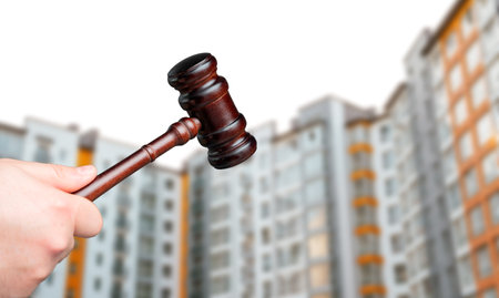 Judge's gavel against the background of residential high-rise buildings. Real estate court decisions. Property inheritance litigation. Establishment of ownership.の写真素材