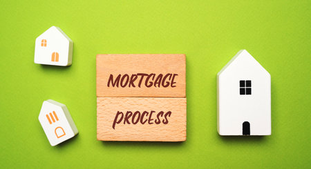 Mortgage process concept: pre-approval, house shopping, mortgage application, loan processing, underwriting and closing. Wooden blocks and miniature housesの写真素材
