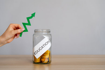 Glass jar with coins with the word Education and green up arrow. The concept of education for yourself or children. Accumulation of money for study. Distribution of cash savings. student loansの写真素材