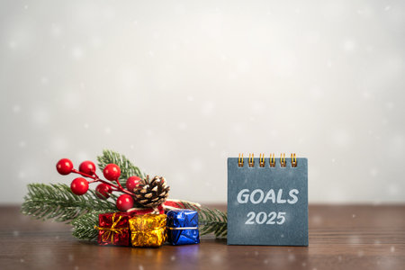 Notebook Goals 2025 and Christmas tree with gifts. Planning, plans and tasks in new year. New creative ideas. Festive atmosphereの写真素材