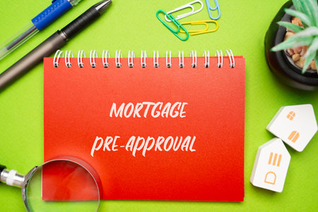 Mortgage pre-approval concept. Preliminary evaluation by a lender to determine the maximum loan amount a borrower can qualify for based on their financial status. Notepad, houses and magnifying glassの写真素材