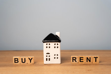 Real estate concept. Renting apartment. Rental home. Buying or purchasing housing. Make the right decision. Miniature house with the words rent or buyの写真素材