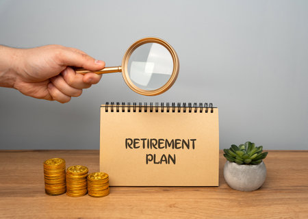 Retirement plan concept. Financial arrangement designed to help individuals save and invest for their retirement years. Notebook with description, man and coinsの写真素材