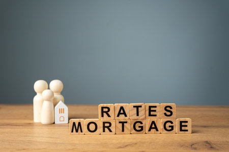 Loan and credit interest. Apartments, housing and house. Real estate market analysis concept. Business and finance. Wooden blocks with the words Rates mortgage and family with house.の写真素材