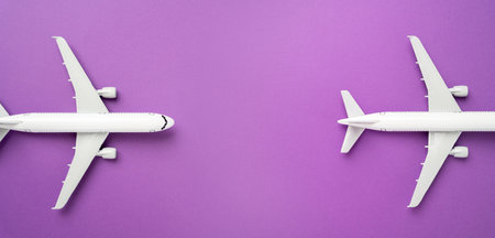 Two airplanes on a lilac background and space for text. Passenger flights. Air travel, aviation industry, airline services.の写真素材