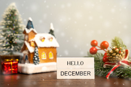 Hello December blocks against the background of a Christmas tree and a house with snow. Concept of the beginning of a new winter seasonの写真素材