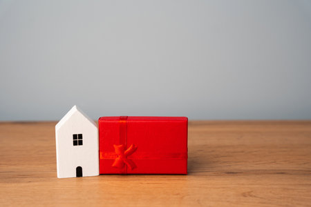 Miniature house and gift box. Housing as a gift. Win an apartment in the lottery. To inherit property. Holiday discounts. Buying an apartment at a low price. Sale of real estate. Presentの写真素材