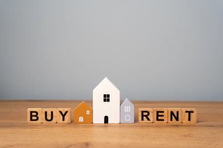 Real estate concept. Renting apartment. Rental home. Buying or purchasing housing. Make the right decision. Wooden houses with the words rent or buyの写真素材