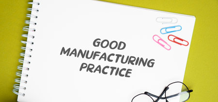 Good Manufacturing Practice notes. GMP is a series of protective measures prepared for the production of products that directly affect human health. Notepad with description on the tableの写真素材