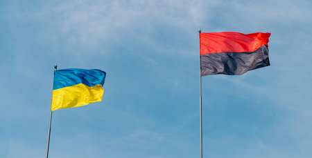 Ukrainian flag against the sky with a red and black flag symbolizing the war in Ukraine. Concept of the Ukrainian nation.の写真素材