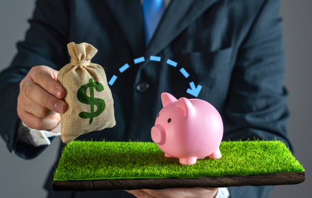 A businessman puts money into savings. Financial security and smart money management. Funds into a savings account, building wealth, securing the future, and practicing responsible financial planning.の写真素材