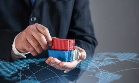 Businessman holding shipping containers against world trade map. Global trade, logistics, and commerce. Symbolizing international supply chains, exports, imports, and the expansion of global markets.の写真素材