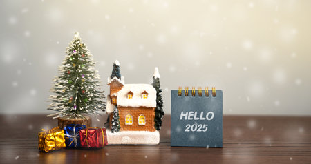 Notebook with Hello 2025, Christmas tree, house and gifts. Merry Christmas and Happy New Year! Xmas concept. Festive winter holiday. Snowfallの写真素材