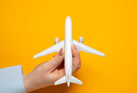 A woman launches a miniature passenger plane for takeoff. Concept of the beginning of a journey. Setting ambitious travel goals. Launch of new life experiences.の写真素材