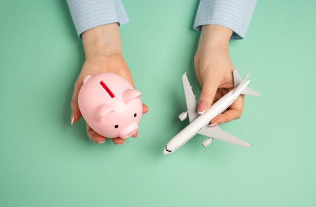 Piggy bank and passenger plane. Save on flights. Accumulate bonuses under the loyalty program. Maximizing discounts on airline tickets. Financial planning for vacations and smart spending.の写真素材
