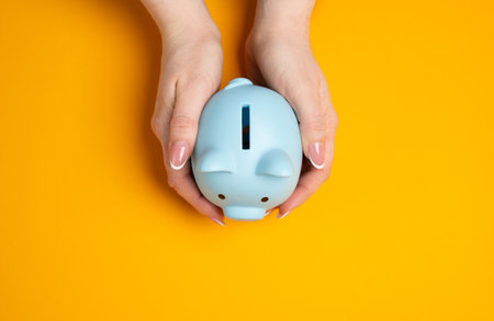 Piggy bank in hands. Concept of savings. Financial security, saving money, and smart budgeting. Careful planning, building a financial cushion, and future investments. Retirement fundsの写真素材