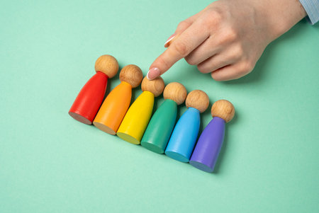 Hand chooses figures of people among LGBT representatives. Find yourself in the list of sexual orientations. Self-identification, exploring sexual orientations, and embracing personal identity.の写真素材