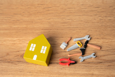 Miniature house and repair tools: pliers, saw, brushes, hammer. Concept of repair and maintenance of housing.の写真素材