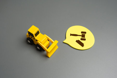 Bulldozer and the symbol of the judge's hammer. Court decisions on demolition and construction. Transfer of land for development, change of the designation status of the territory. Property rightsの写真素材