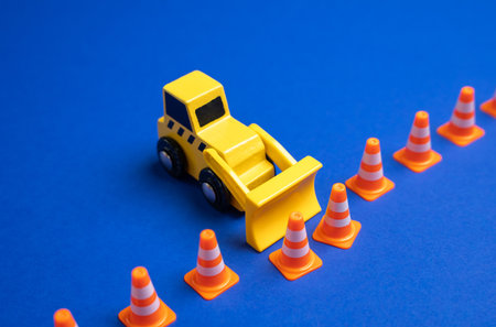 A yellow bulldozer pushes back a boundary of cones. The concept is to expand what is permitted,...