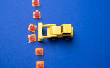 A yellow bulldozer crosses the line of cones. The concept of crossing boundaries and removing...
