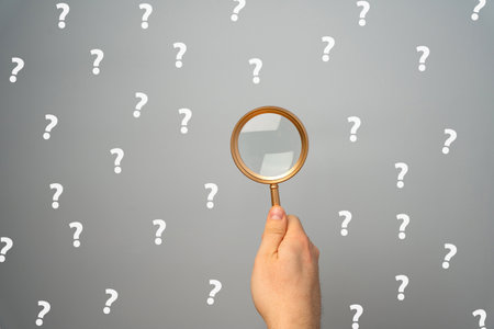 Magnifying glass with a many question mark. Looking for an answer. Search and analysis, analytics and study. Pay attention to details and problems. Find something. Journalistic investigationsの写真素材
