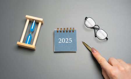 Paper calendar 2025 and hourglass Beginning of a new year. Plan, planning and achieving goals. Copy spaceの写真素材