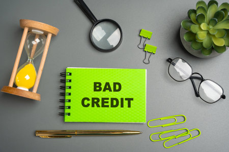 Bad credit concept. Person has a low credit score or a poor credit history, usually because they haven't paid back debts on time or have borrowed too much money. Notepad with messageの写真素材