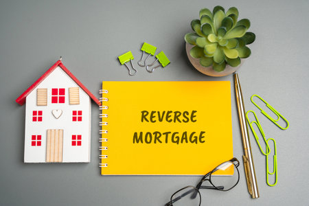 Reverse mortgage concept. Type of loan available to homeowners aged 62 or older, allowing them to convert part of the equity in their home into cash. Business and finance. Notes, inscription, houseの写真素材