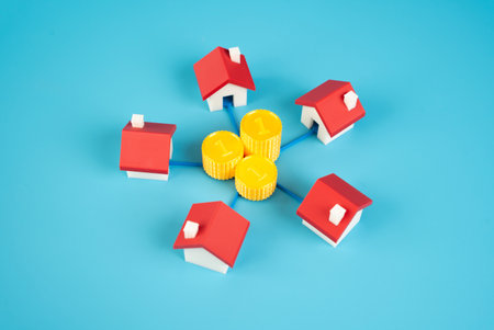 Money coins are surrounded by houses. The corporation of housing estates for raising funds for repair and improvement of infrastructure and landscape. Co-financingの写真素材