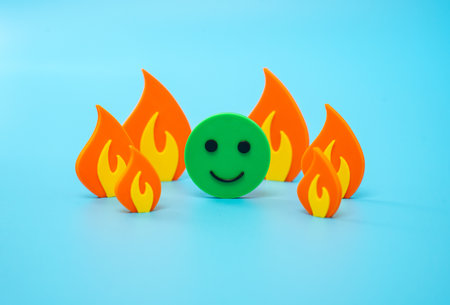 Smiling face emotion of joy among fire and flame. Great mood, enthusiasm. Be on trend. Stay positive no matter what. Carefree. Positivity in adversity or social commentary on indifference.の写真素材