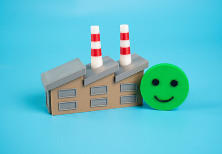 Factory building and smiling emoji. Good investment climate. Excellent economic health. Good profit and order load. Productivity, profitability, and investor confidence thriveの写真素材