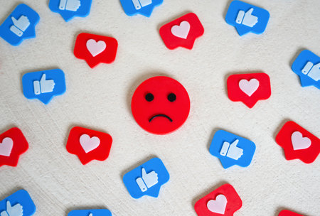Sad face among social media likes. Burnout and doomscrolling. Chasing likes, social media addiction. Mental health challenges, emotional fatigue, and the dark side of digital life. Dopamine loopsの写真素材