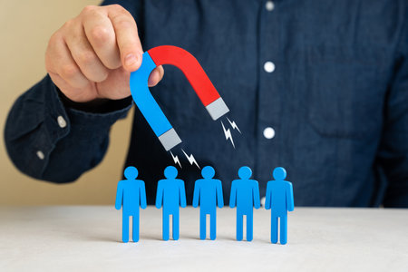 A man with a magnet attracts people. Leadership charisma. Attracting clients or hiring. Recruitment strategies, business outreach, customer acquisition.の写真素材
