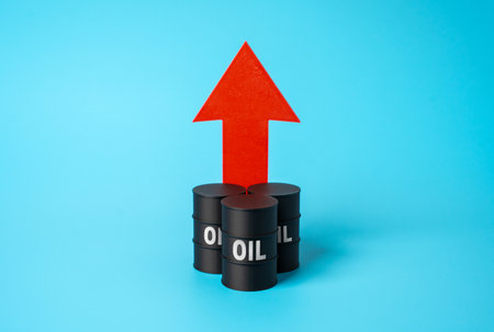 Rising oil prices. Oil barrels and an arrow pointing up. Rising demand and limited supply create global market pressure. Energy crisis. Dependence on fossil fuels. Alternative energy developmentの写真素材